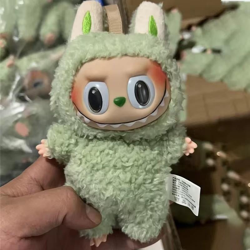 Green fuzzy monster plush doll with big eyes and ears held in hand collection of activity toys for kids UAE